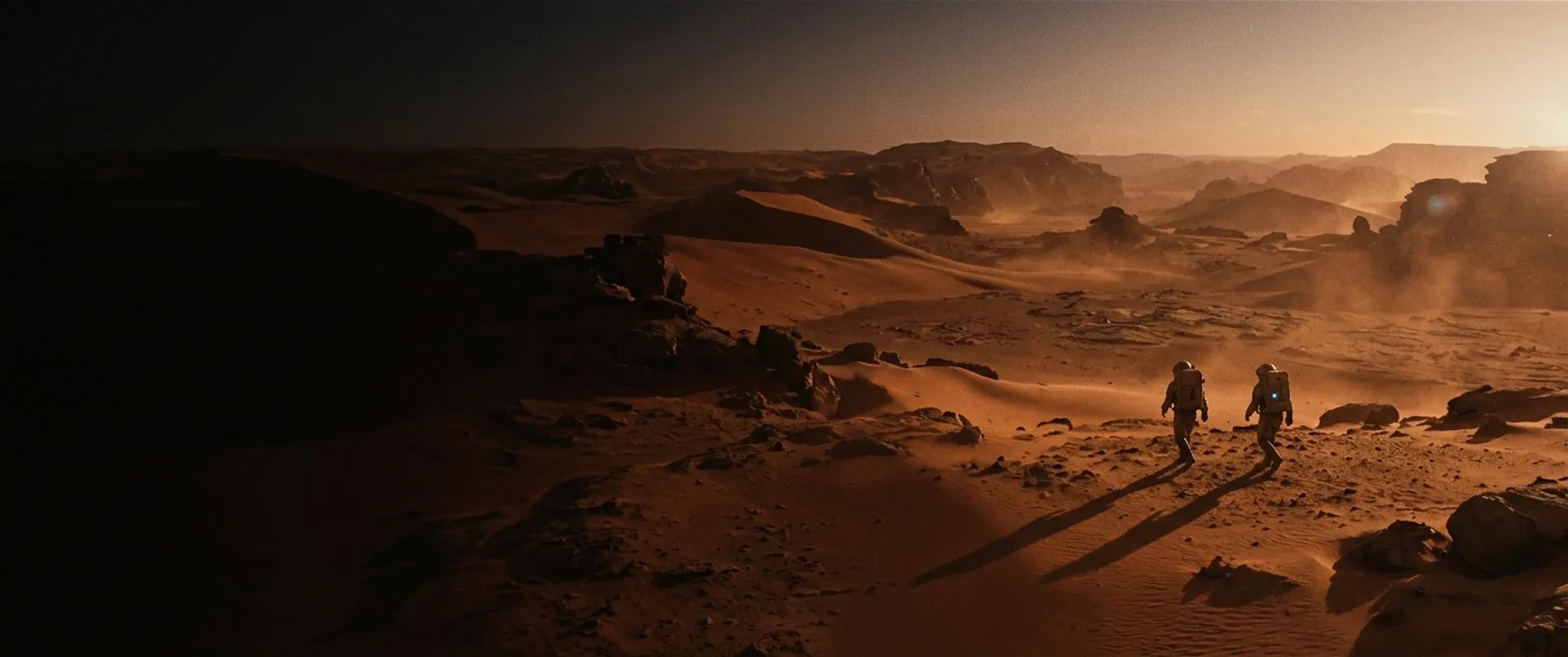 Explorers crossing Martian dunes at sunset